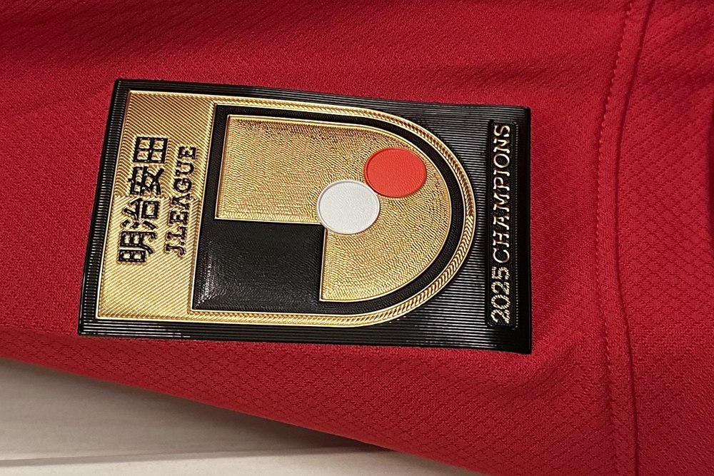 鹿島アントラーズ2026-27ユニフォームの右袖に付いた「明治安田J.LEAGUE 2025 CHAMPIONS」の金色の優勝エンブレム