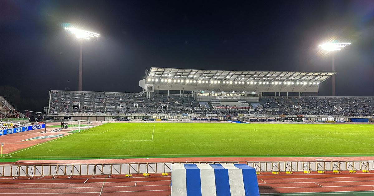 ナイター照明に照らされた水戸信用金庫スタジアムのピッチとメインスタンド
