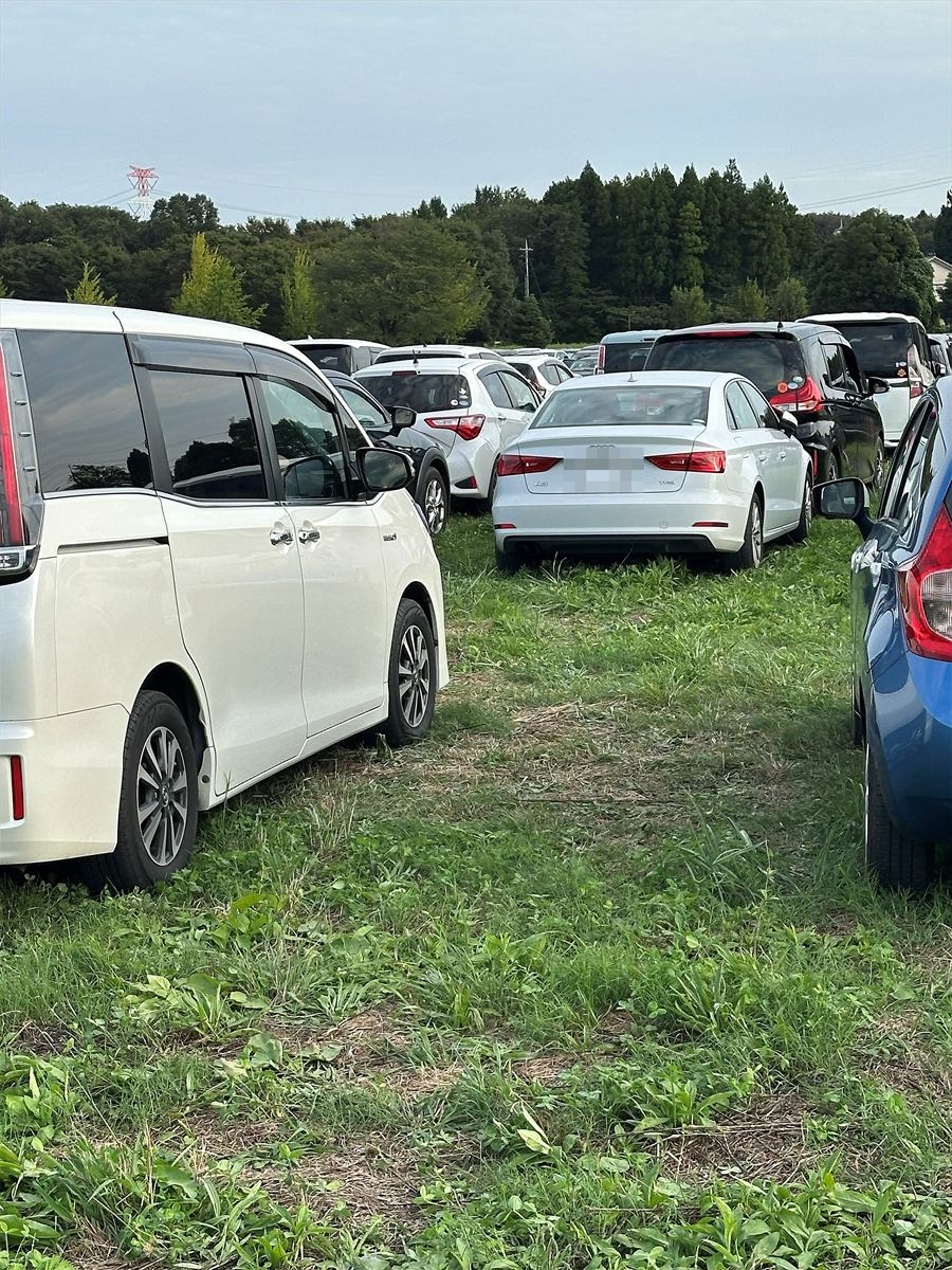 水戸信用金庫スタジアムの第6駐車場②。舗装されていない草地に車が並んで駐車している
