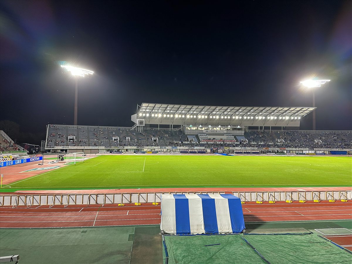 試合後の水戸信用金庫スタジアム。照明が点いたピッチとメインスタンド